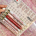 Set of five plastic retractable ballpoint pens with nurse-themed designs on the barrels.