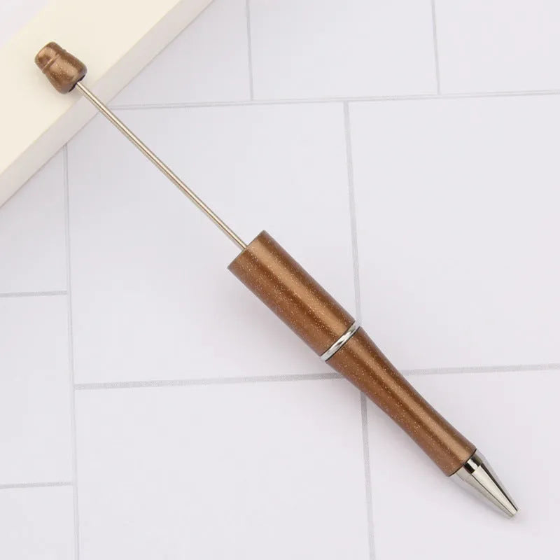 Colourful spinning ballpoint pen with plastic beads on a white background.