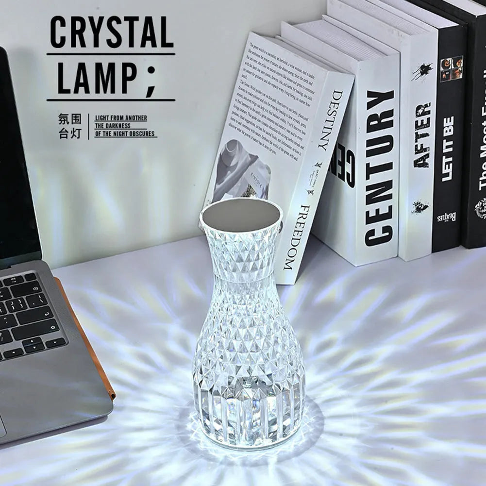 Vase-shaped crystal table lamp with LED lights and remote control on a bedside table