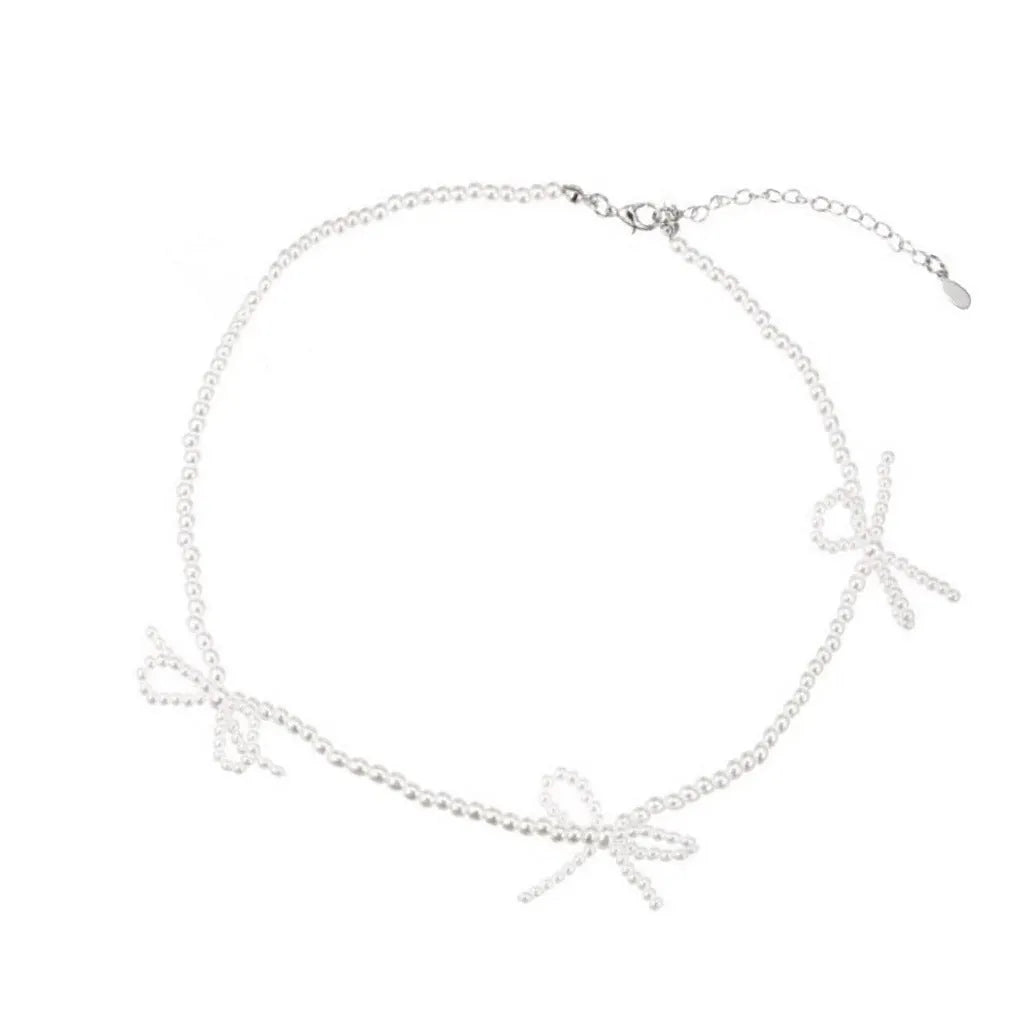 White bow pearl necklace with geometric clasp on woman at clavicle length