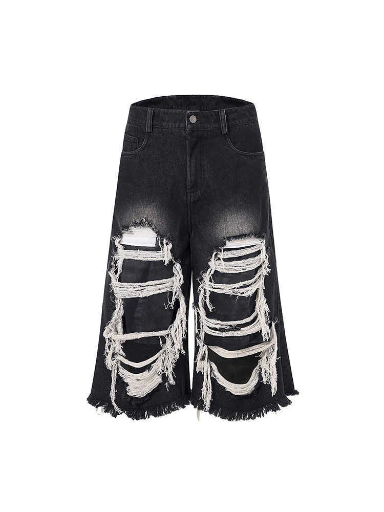 Black cropped wide-leg women's jeans with a ripped patch detail and a mid-high waist.