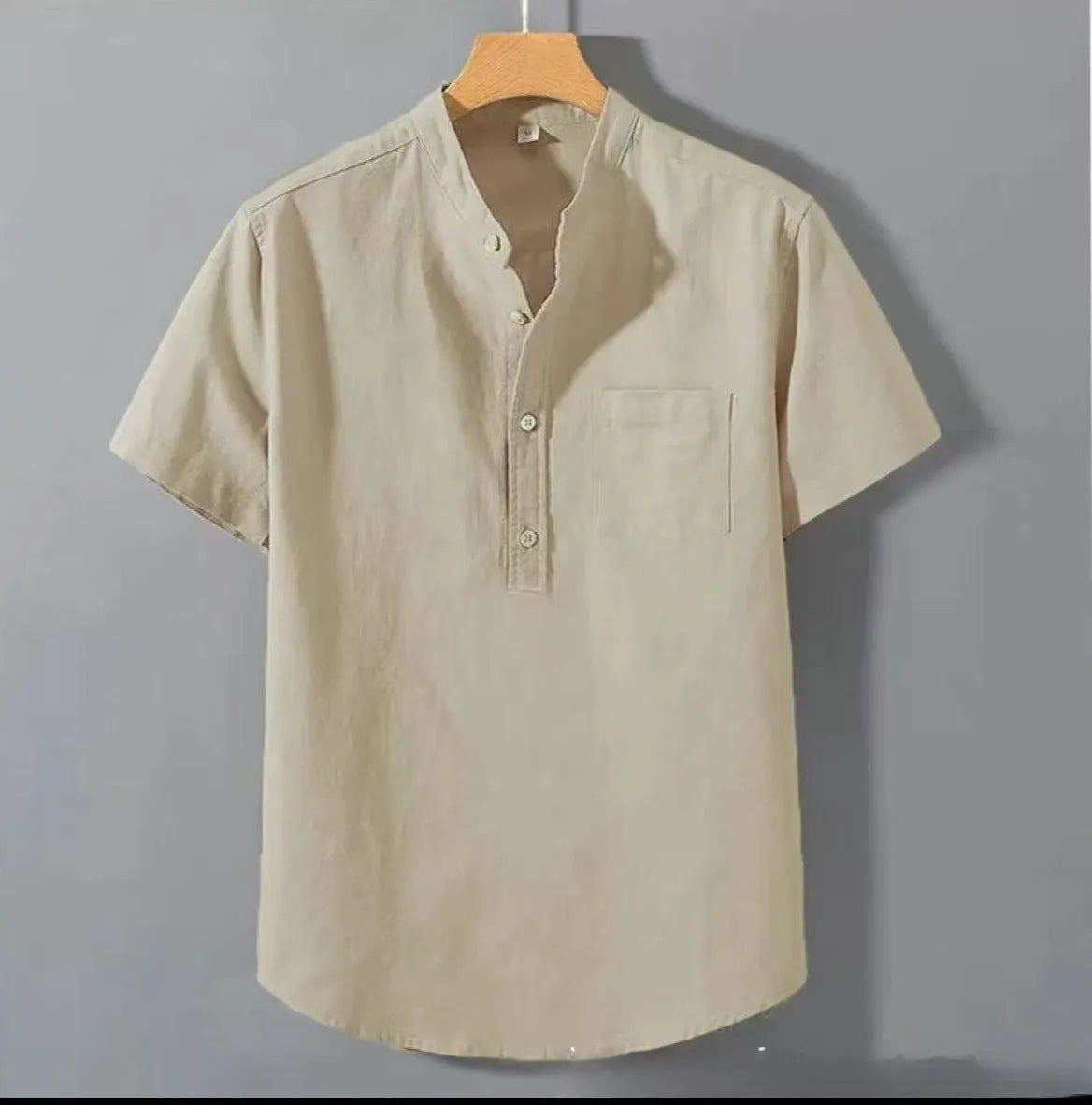 Man wearing a beige short sleeve linen and slub cotton casual shirt with a stand collar.