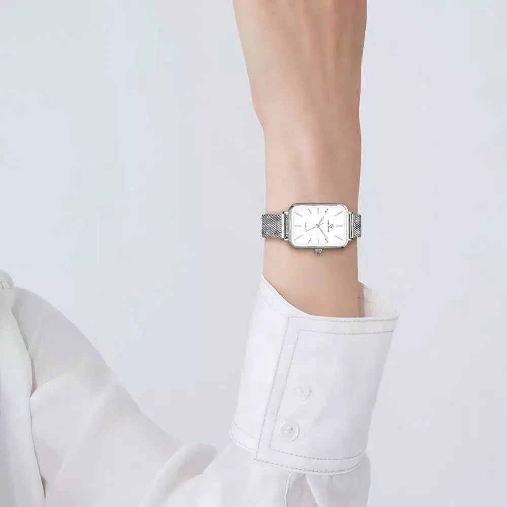 Rose gold and silver women's waterproof quartz watch with woven steel strap on a wrist.