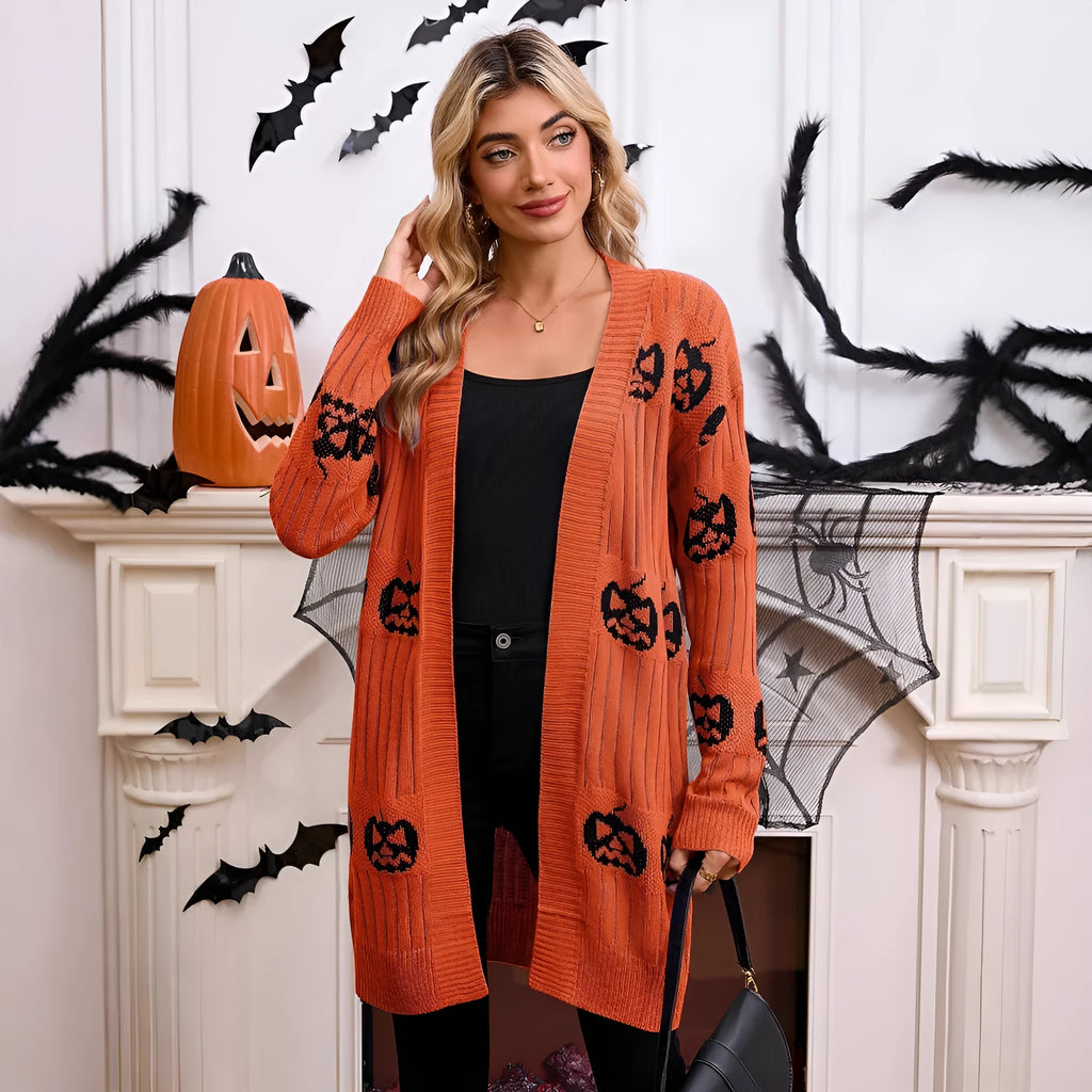 Women's black cardigan with orange pumpkin head jacquard knit pattern, shown as a medium-length coat.
