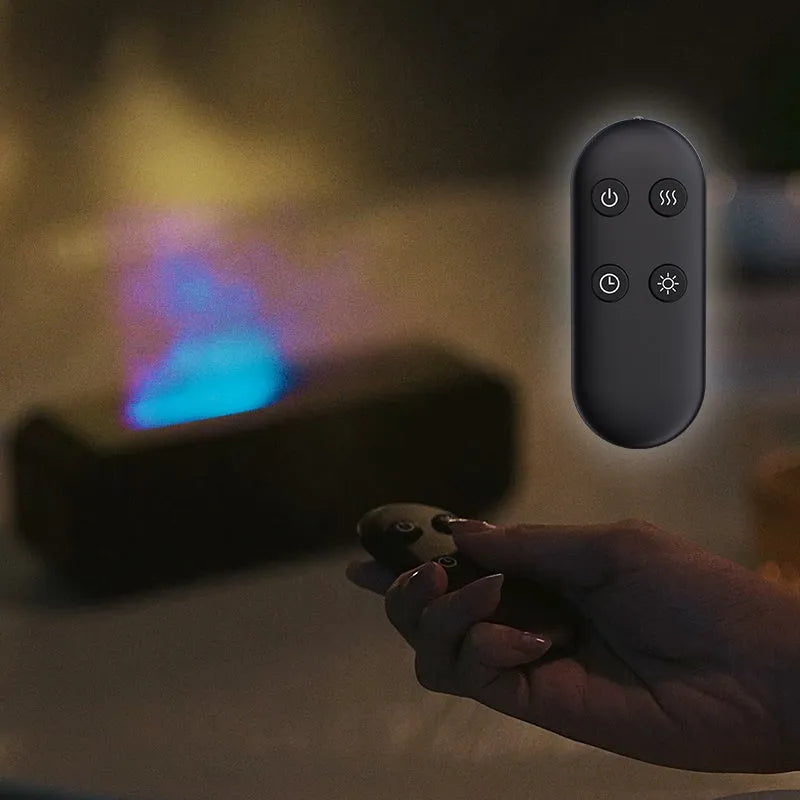 Black and white USB essential oil aromatherapy diffuser with colour-changing lights and remote control on a table