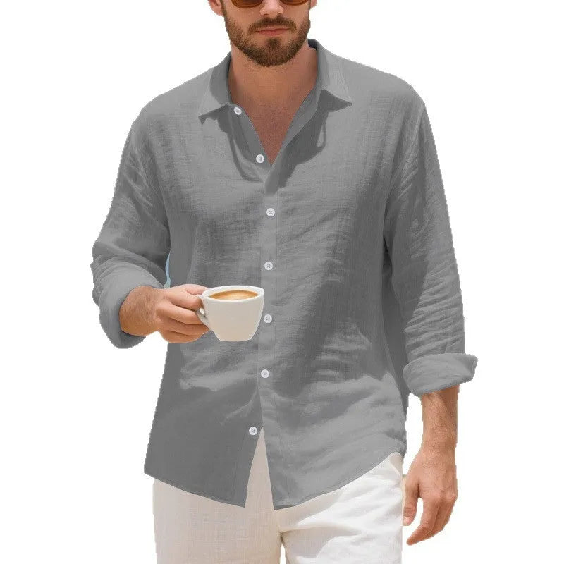 A man wearing a loose-fit light blue linen casual shirt with a non-iron finish, buttoned front and standard collar.