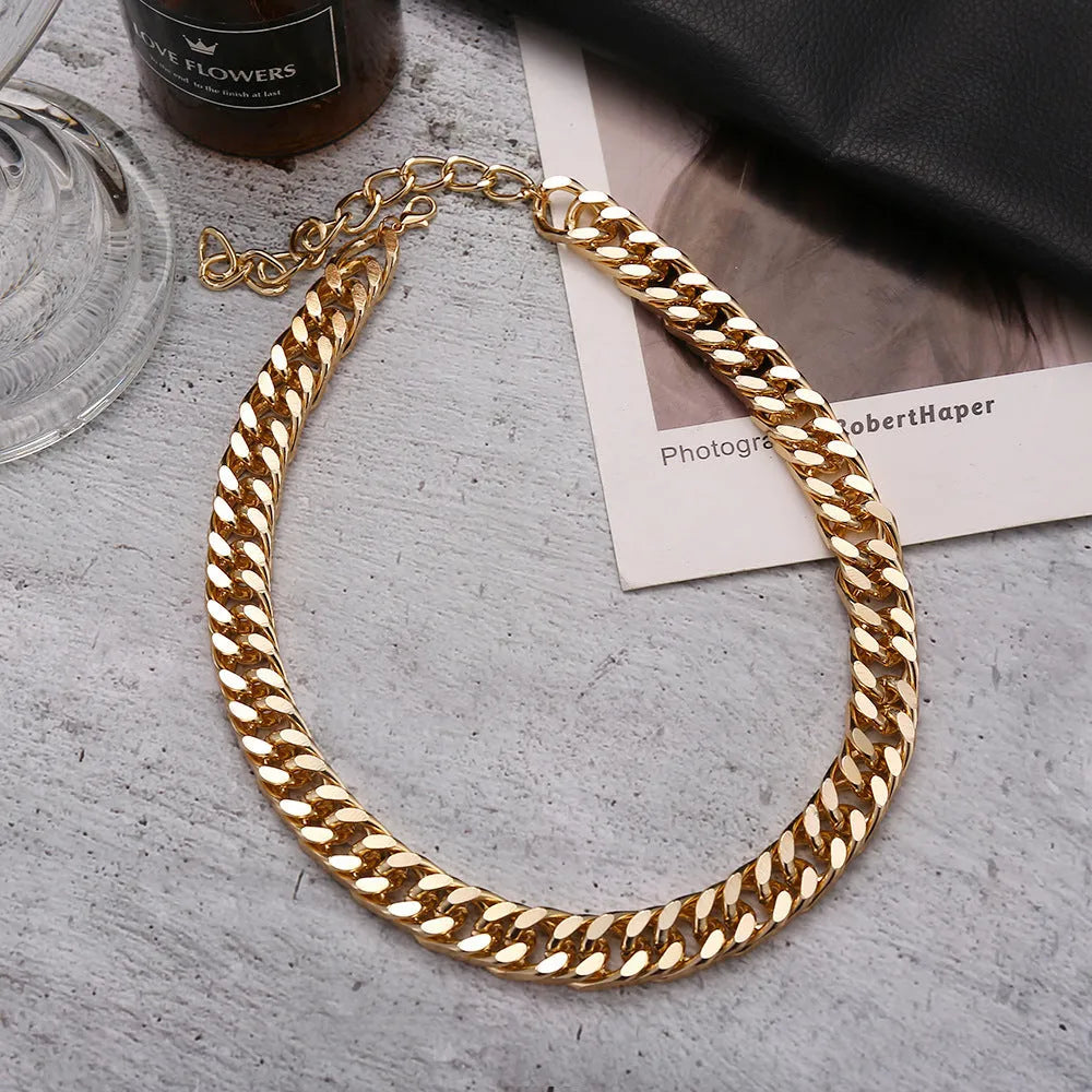 Gold women's thick link chain necklace with a 6cm drop pendant on a model.