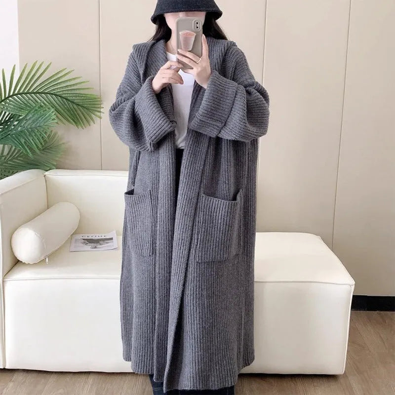 Women's loose grey hooded cardigan coat with raglan sleeves on a hanger.