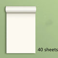 A4 blank draft notebook with picture colour cover, open to show unlined pages, placed on a desk with a pen.