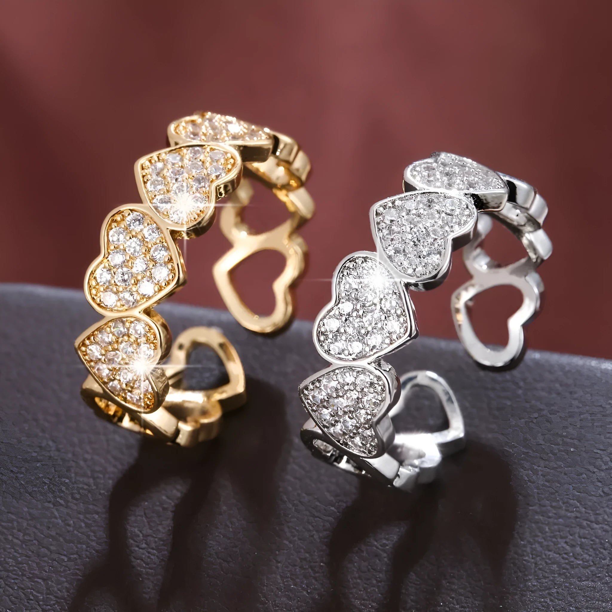 Geometric adjustable love heart ring with diamond-cut facets in gold tone on a wooden surface.