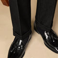 Men's black genuine leather tassel loafers with a polished finish and rubber sole.