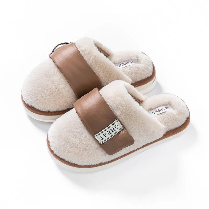 Beige plush velcro slippers with a round toe and non-slip plastic sole on a wooden floor.