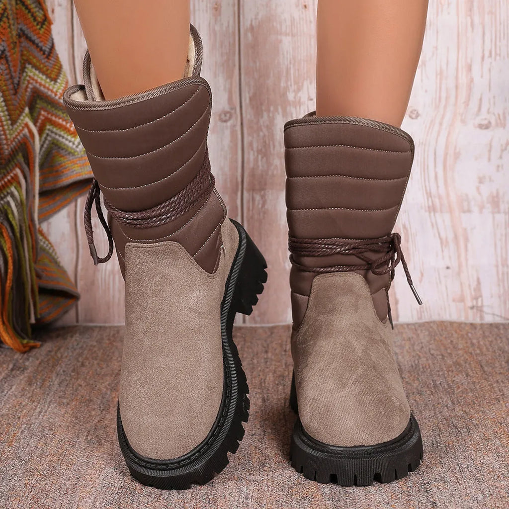 Women's black chunky heel snow boots with lace-up design and suede upper.