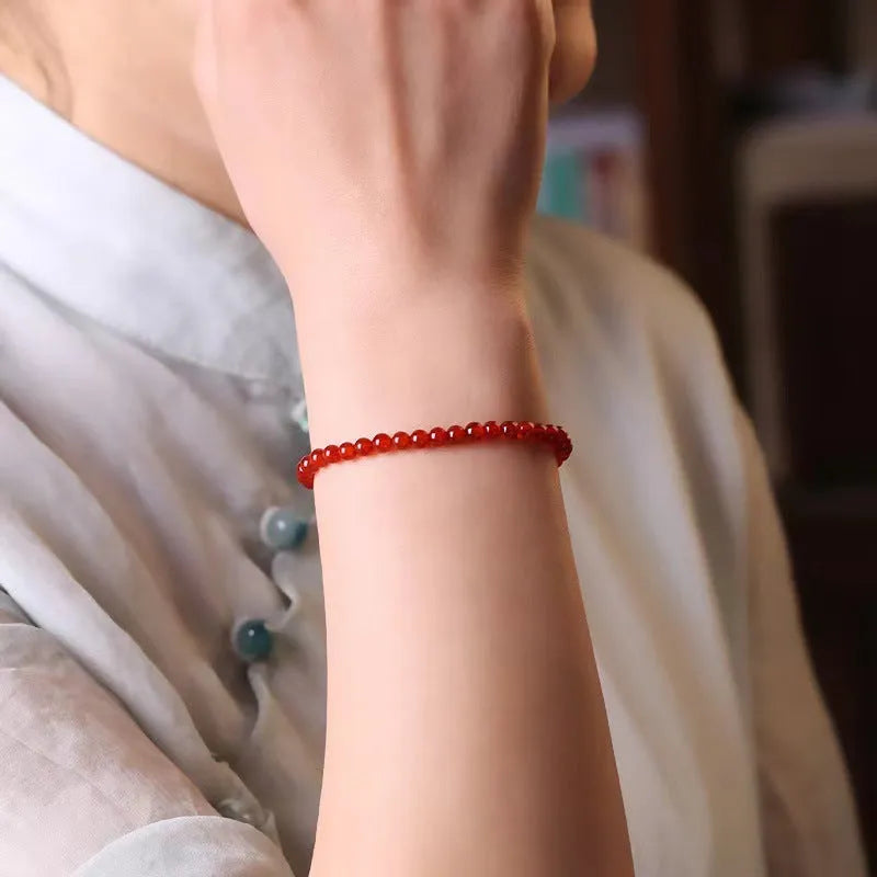 Ultra-thin red agate bracelet for women on a white background.