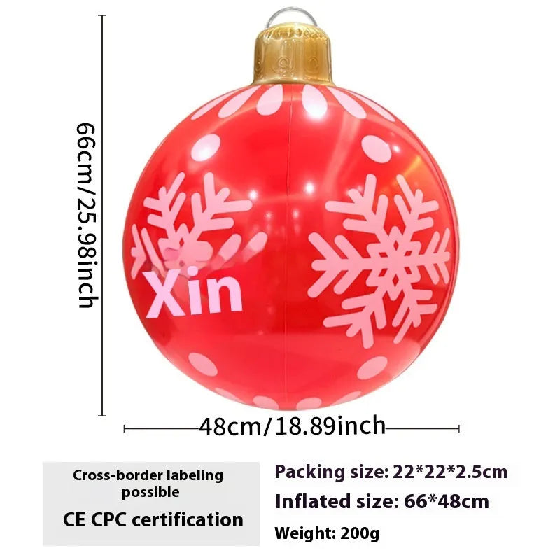 Large red and white inflatable Christmas ball with flashing lights standing in a garden.
