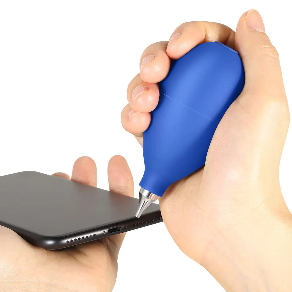 Blue hand-held rubber dust blower cleaning tool with tapered nozzle, shown next to a mobile phone for scale