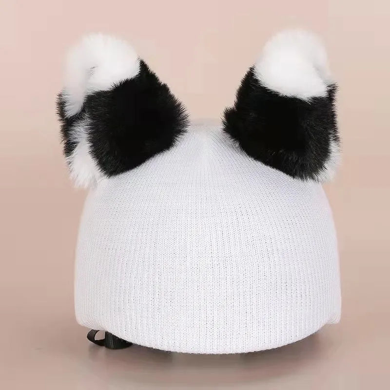 Plush fabric cartoon character helmet cover stretched over a blue hat for children's dress-up.