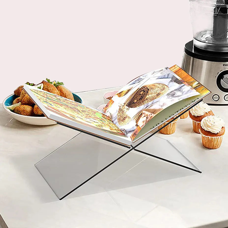 Clear acrylic X-shaped book display shelf holding reading materials on desktop