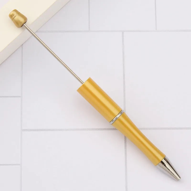 Colourful spinning ballpoint pen with plastic beads on a white background.