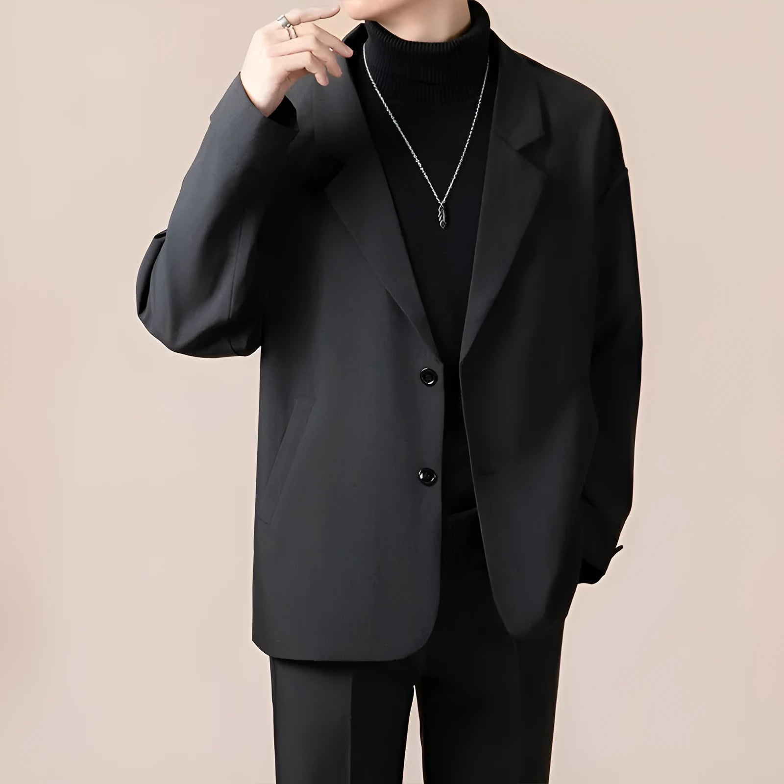 Man wearing a loose fit apricot coloured suit jacket with long sleeves.