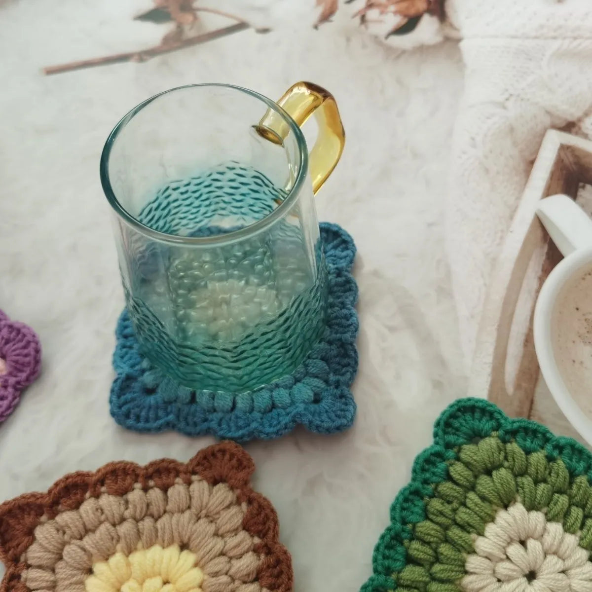 Hand crocheted wool cup coaster in Grandmother Lattice pattern, colour options include Emerald, Sea Salt Blue, Dream Purple, and Fog Brown.