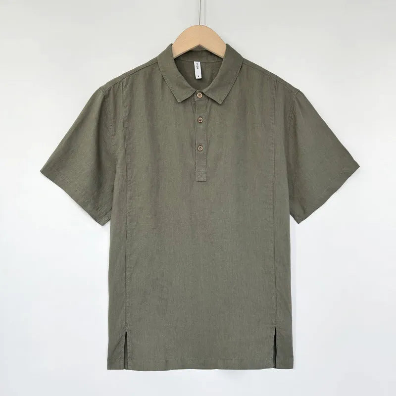 Man wearing a light grey green linen short-sleeve top with thin lapels and a loose fit.
