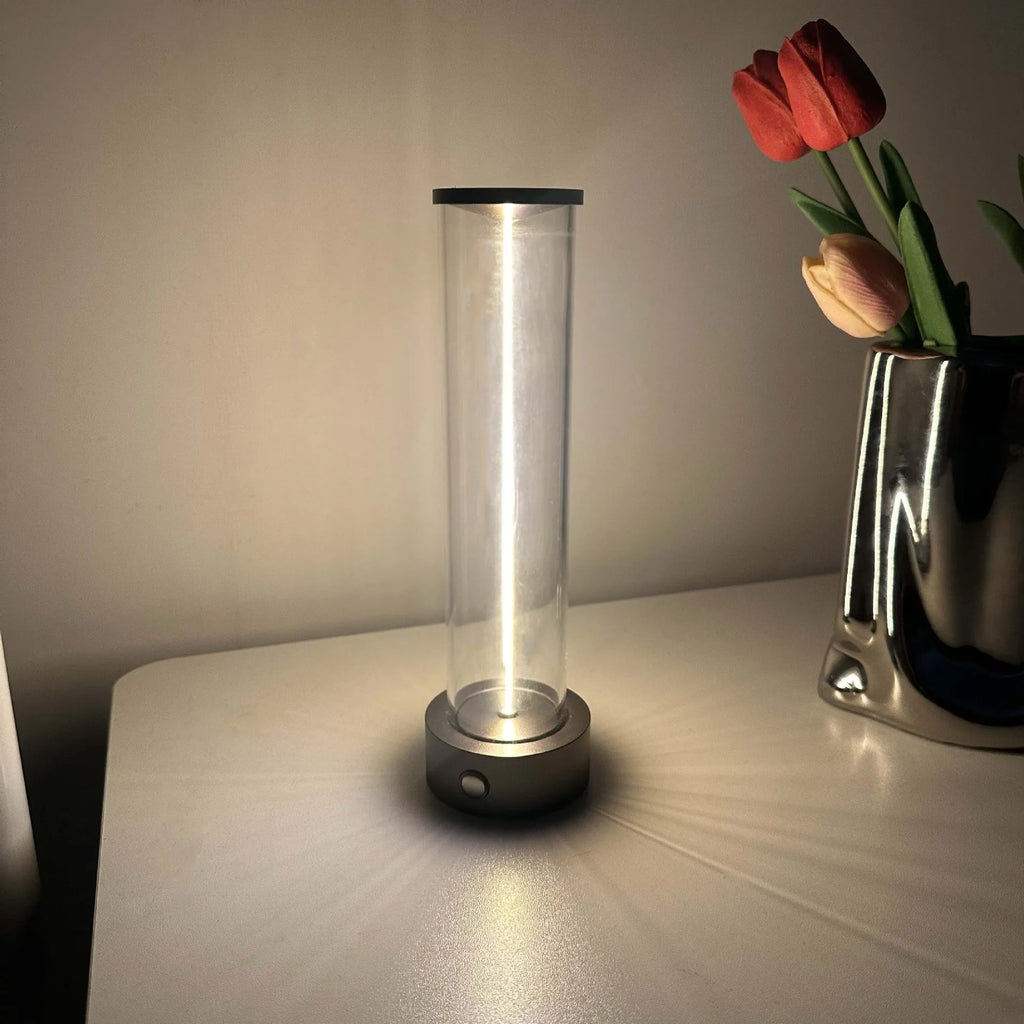 Slim modern glass LED bar night light with magnetic base on a desk surface.