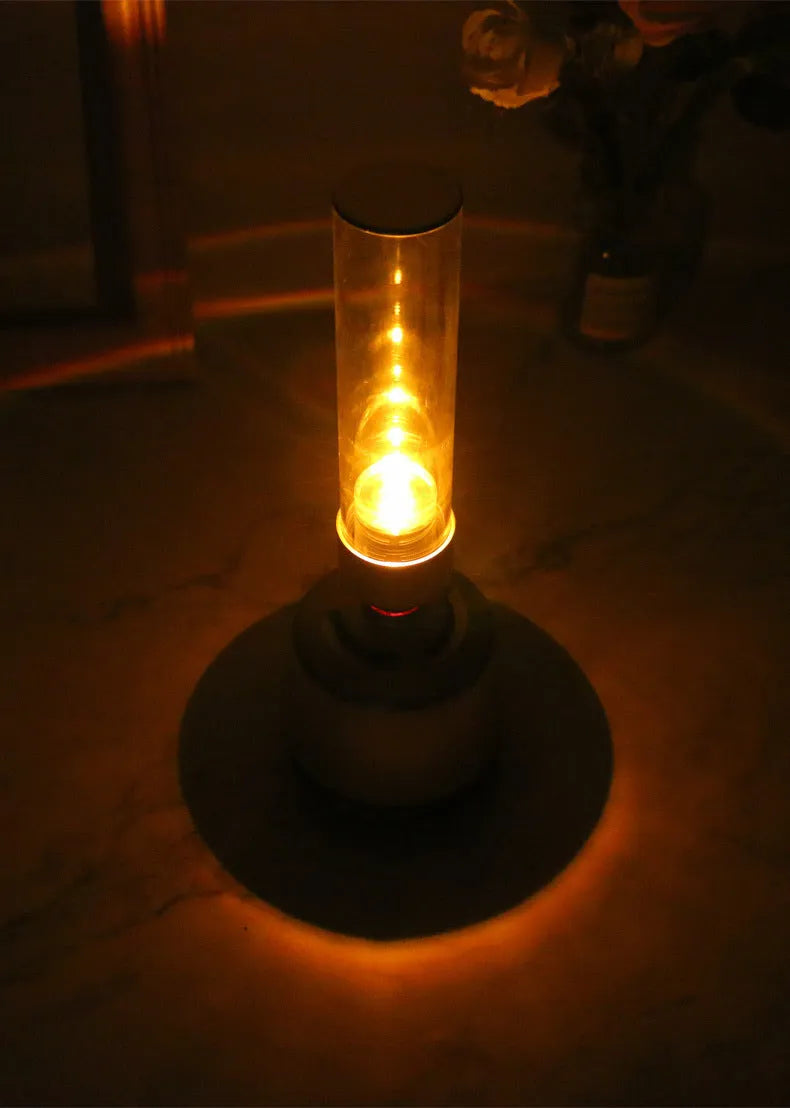 White silver cylindrical Candlelight Bluetooth Speaker Night Light showing warm internal glow and push-button controls.