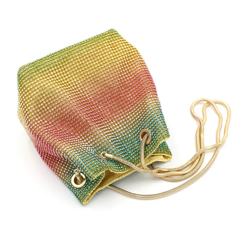Soft rainbow rhinestone bucket bag with adjustable metal chain strap on a 28cm circular base.