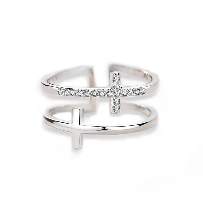 Adjustable open copper ring with a miniature double cross design inlaid with zircon stones.