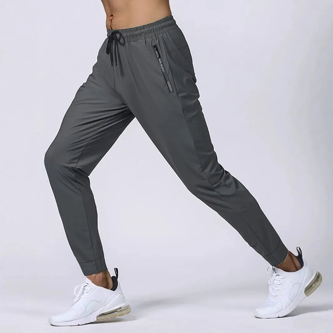Men's loose mid waist jogging sports pants in black, grey, khaki, or blue, high elasticity nylon blend, sizes L to 7XL