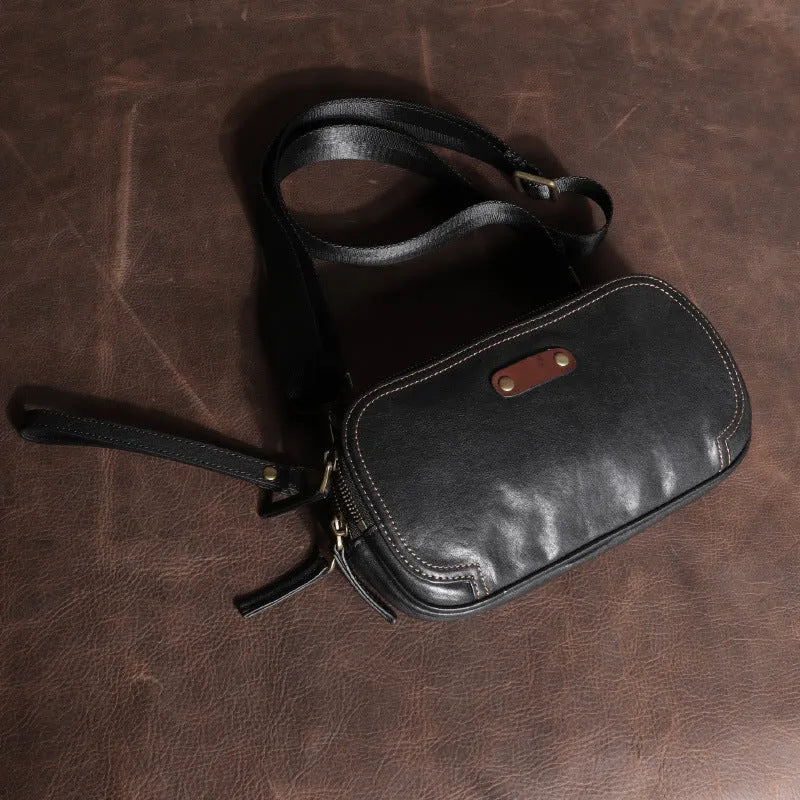 Men's small phantom black cowhide crossbody bag with pillow shape and zipper pockets