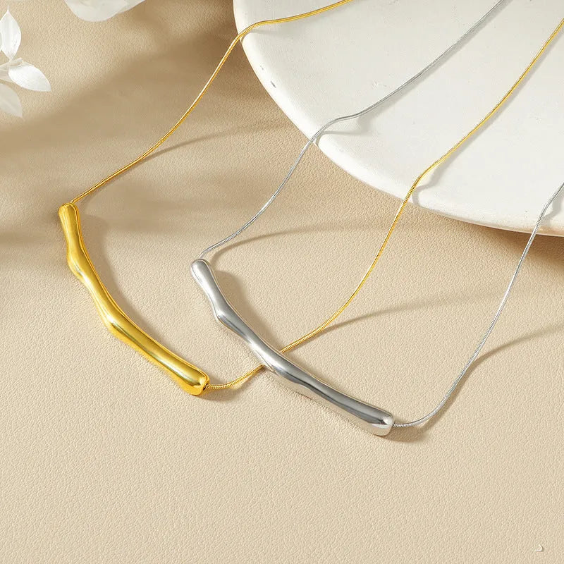 Close-up of a titanium steel women's necklace with an irregular pleated design in a gold electroplated finish.