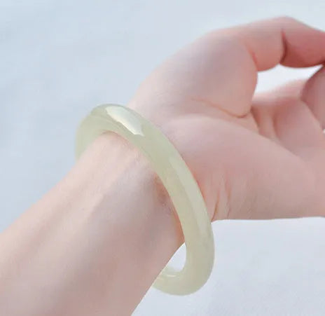Natural ice silk jade round bar bracelet on a white background, showing its smooth texture and solid form.