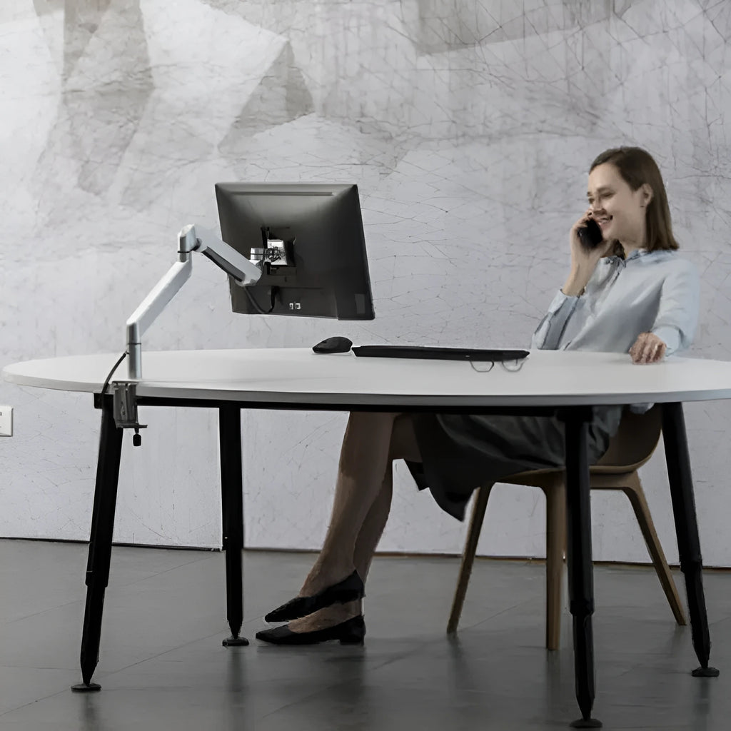 Silver aluminium laptop stand with adjustable air pressure arm bracket holding a MacBook notebook.