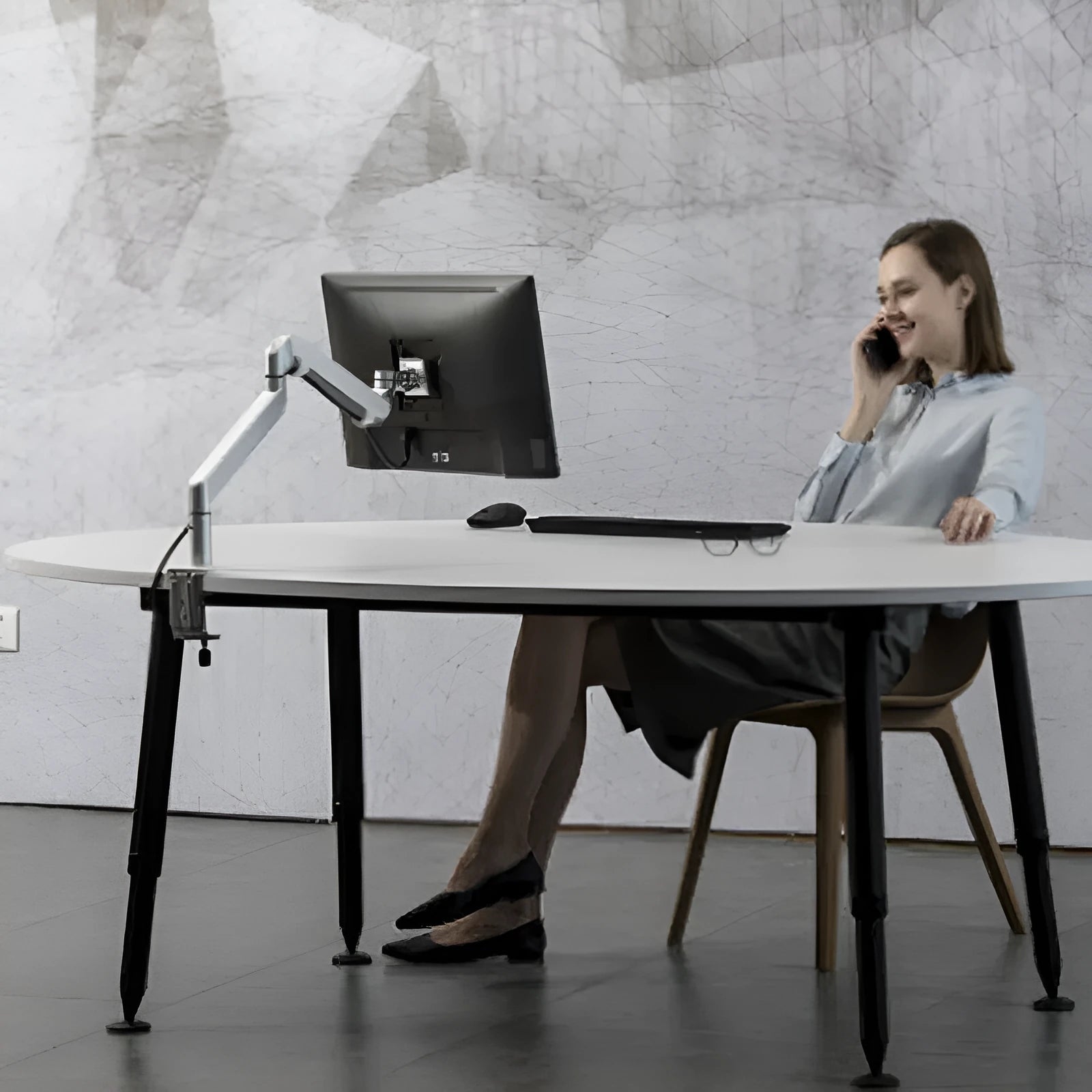 Silver aluminium laptop stand with adjustable air pressure arm bracket holding a MacBook notebook.