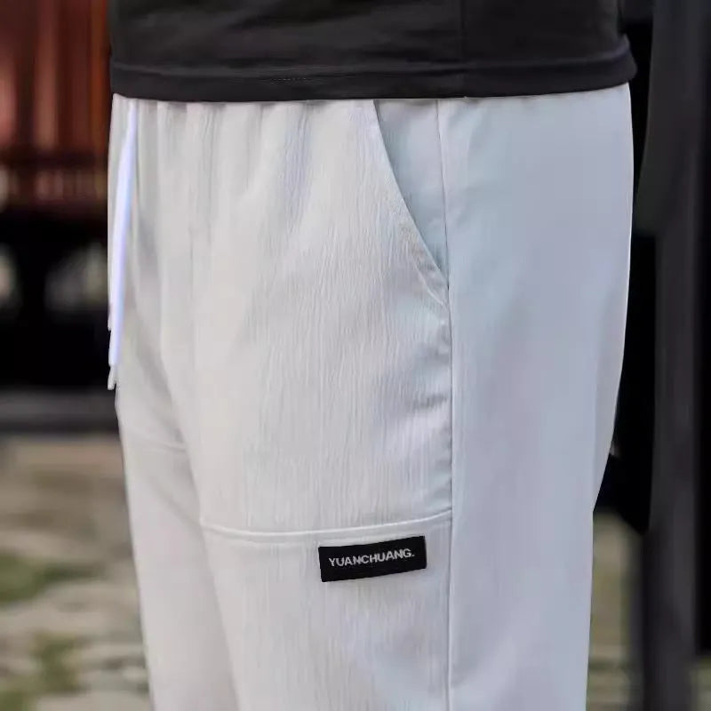 Men's light grey polyester casual trousers for spring and autumn wear.