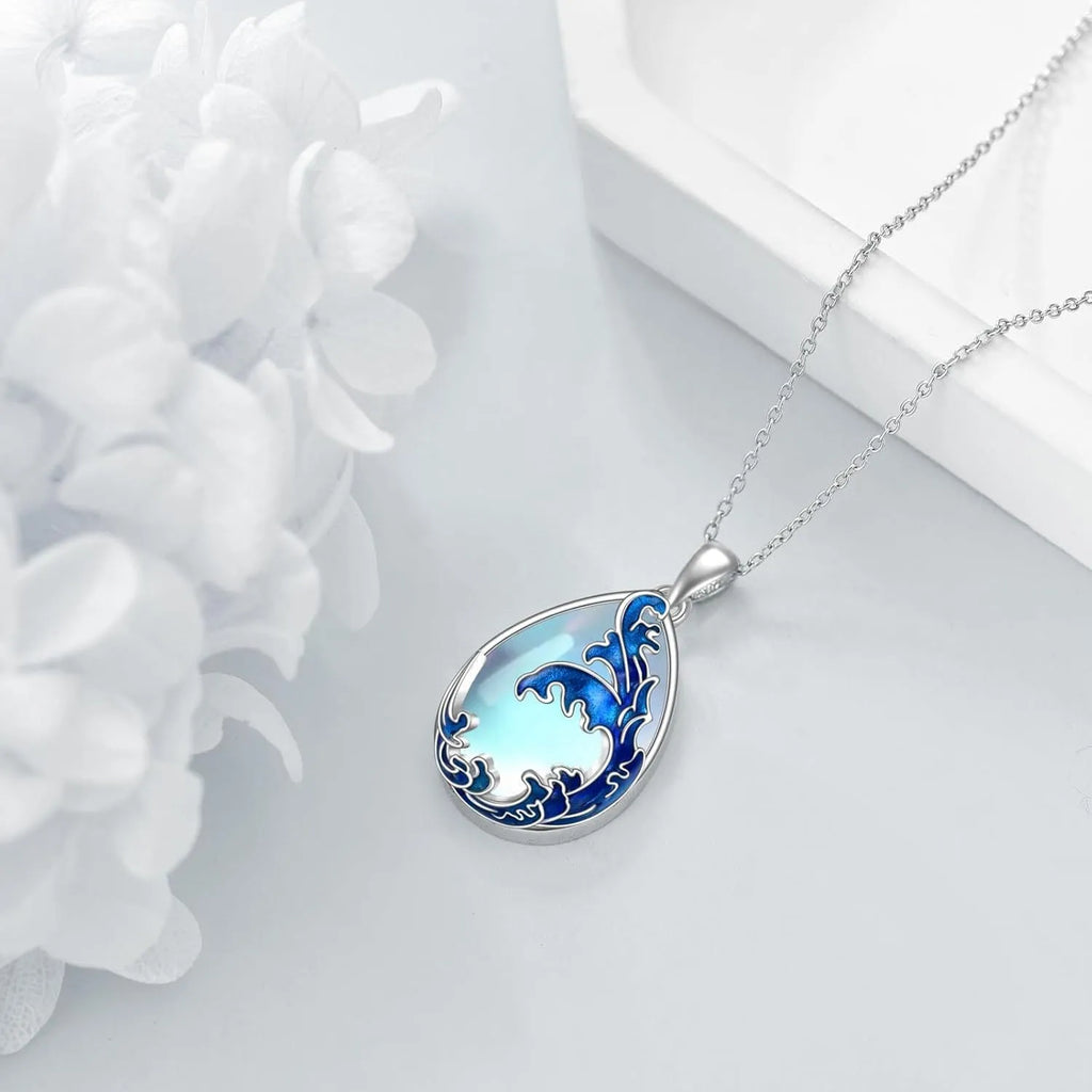 Close-up of a moonstone blue heart-shaped alloy pendant on a women's necklace chain.