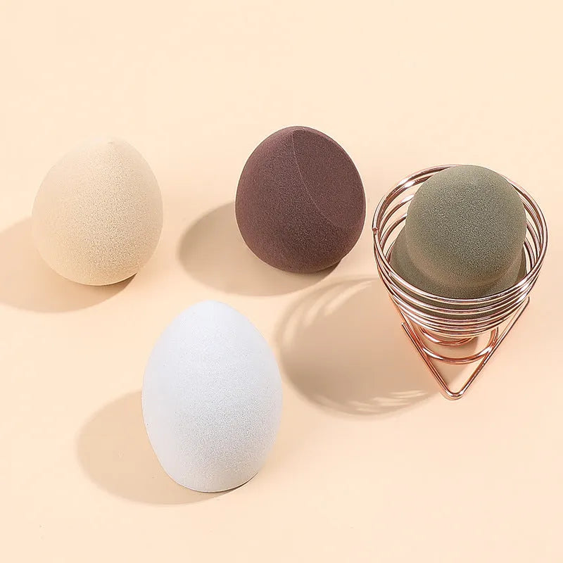 Four coloured hydrophilic polyurethane beauty eggs placed on a metal stand for makeup application