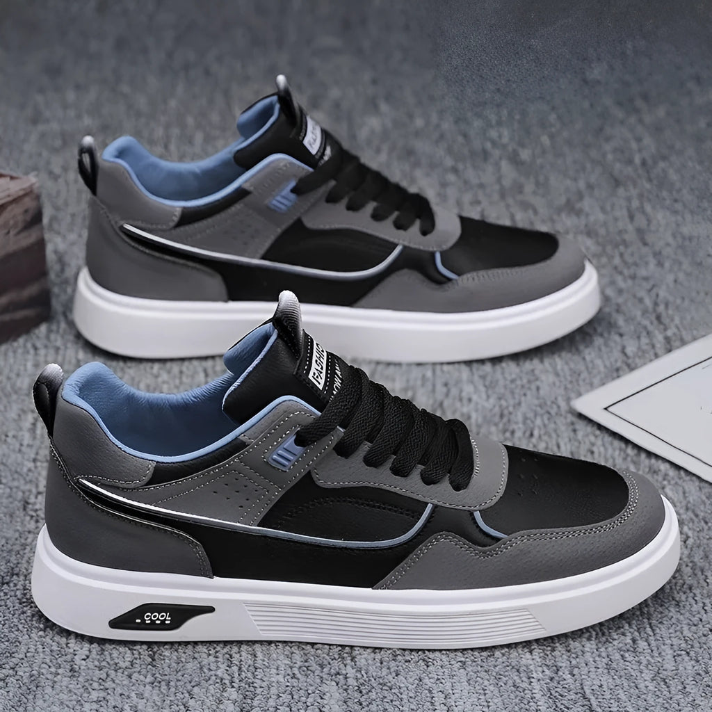Men's beige low-top canvas board shoes with leather stitching details on a white background.