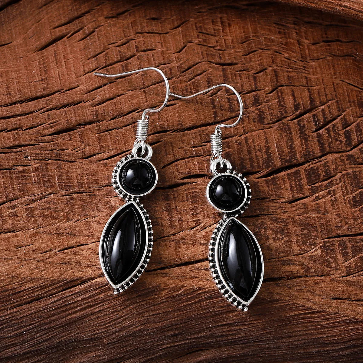 A pair of vintage-style geometric pendant earrings in black and purple with a round detail, on a zinc alloy base.