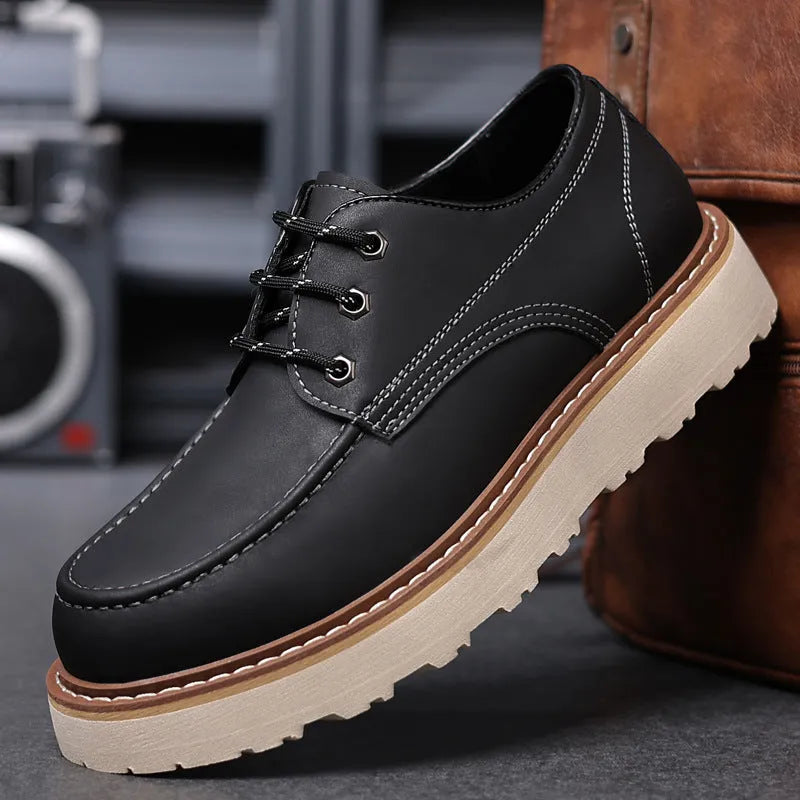 Men's black low-top Martin boots with a round toe and non-slip rubber sole on a plain background.