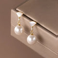 Gold fan-shaped shell pearl earrings in 925 silver with geometric ancient style design for women.