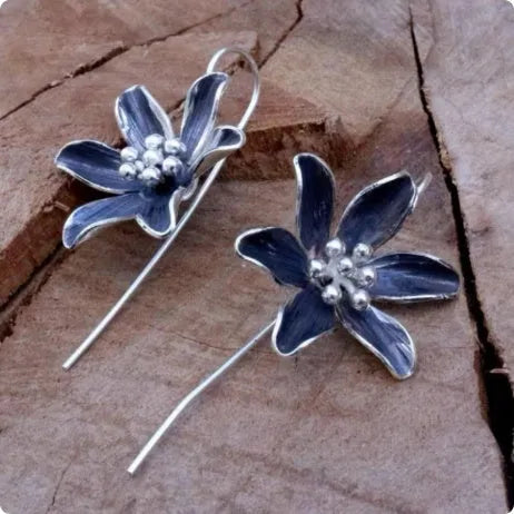 Close-up of a pair of purple alloy flower-shaped earrings with a retro elegant style.