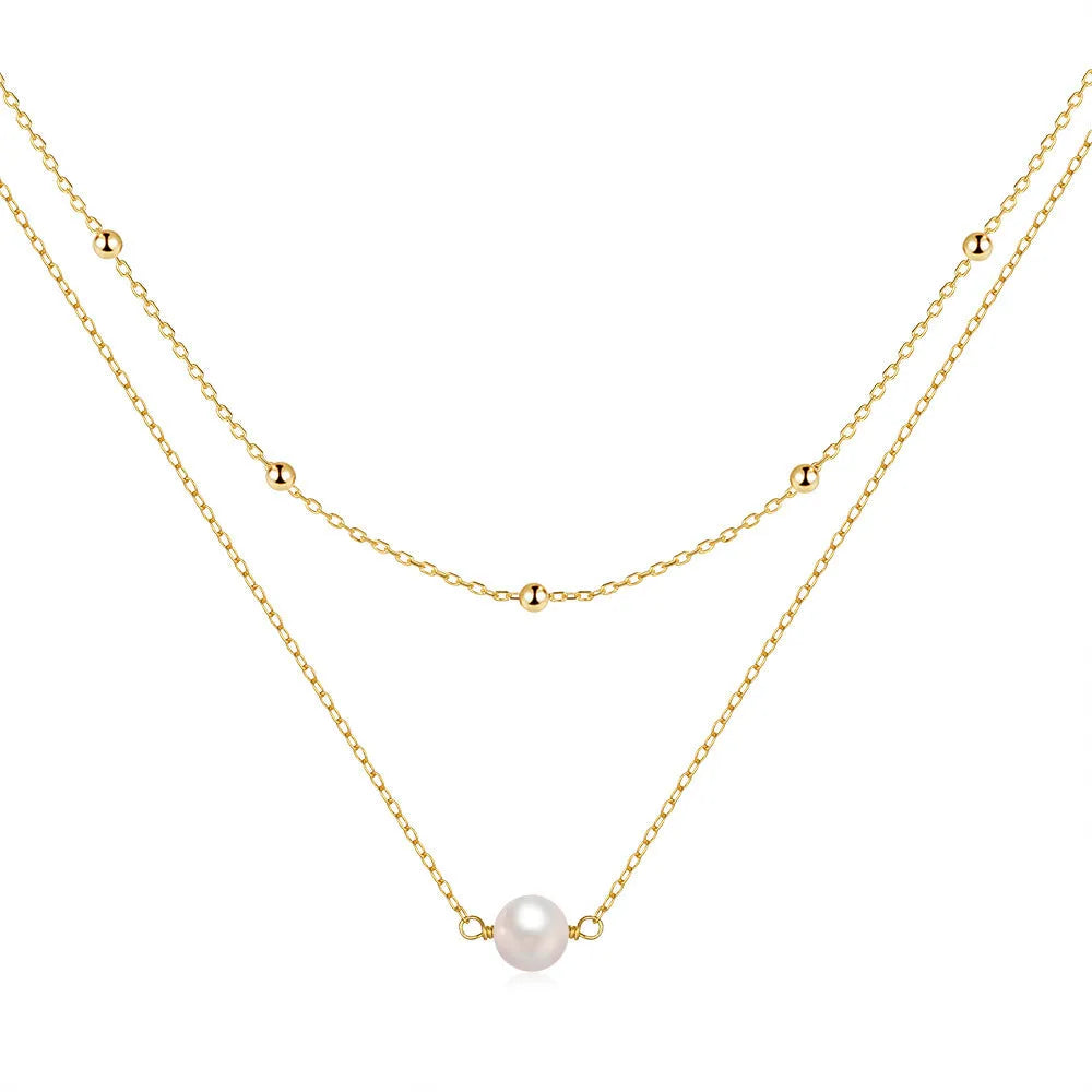 Women's double layer sterling silver necklace with geometric pendant and twin pearls, shown in gold and white gold plating.