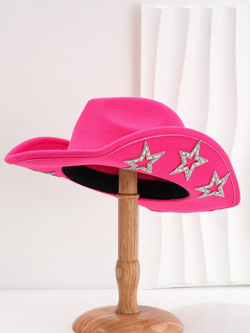 Beige woolen felt western style top hat with a conical crown and a silver hexagonal star decoration on the front.