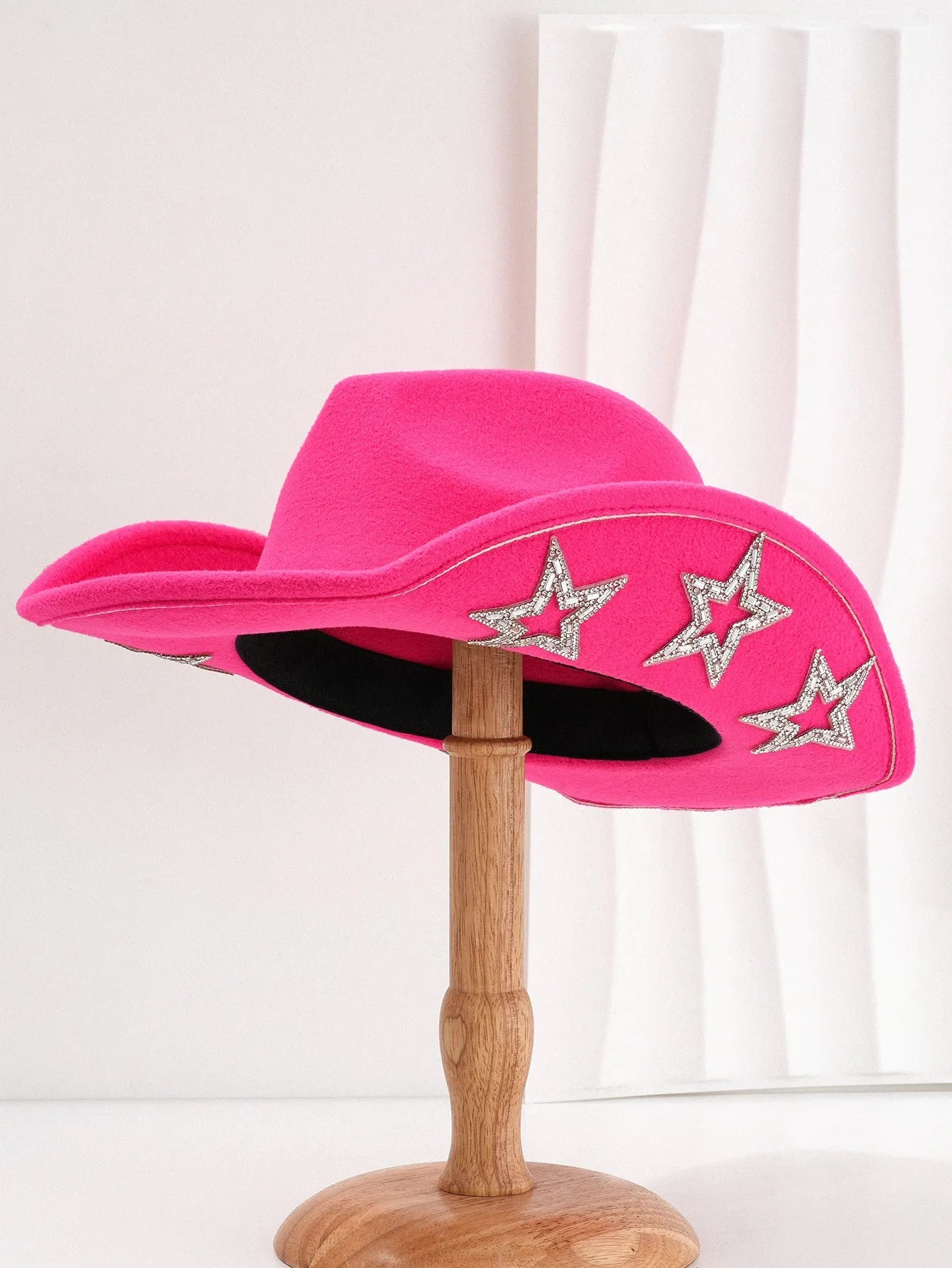 Beige woolen felt western style top hat with a conical crown and a silver hexagonal star decoration on the front.