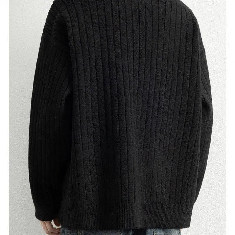 Man wearing a loose grey half-zip textured knit pullover sweater.