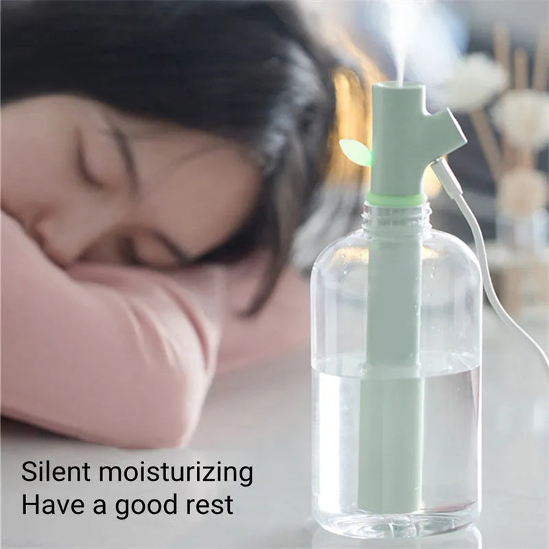 Transparent portable USB air humidifier with adjustable mist settings on a desk