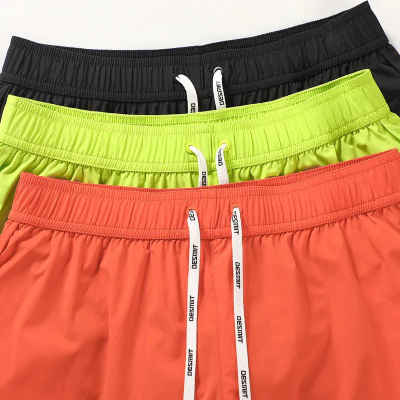 Men's loose beach trousers in polyester with micro elasticity available in black, fluorescent green, and orange red colours
